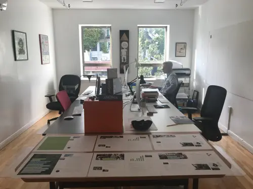 A sunlit hallway at Go West Coworking with local art on the walls